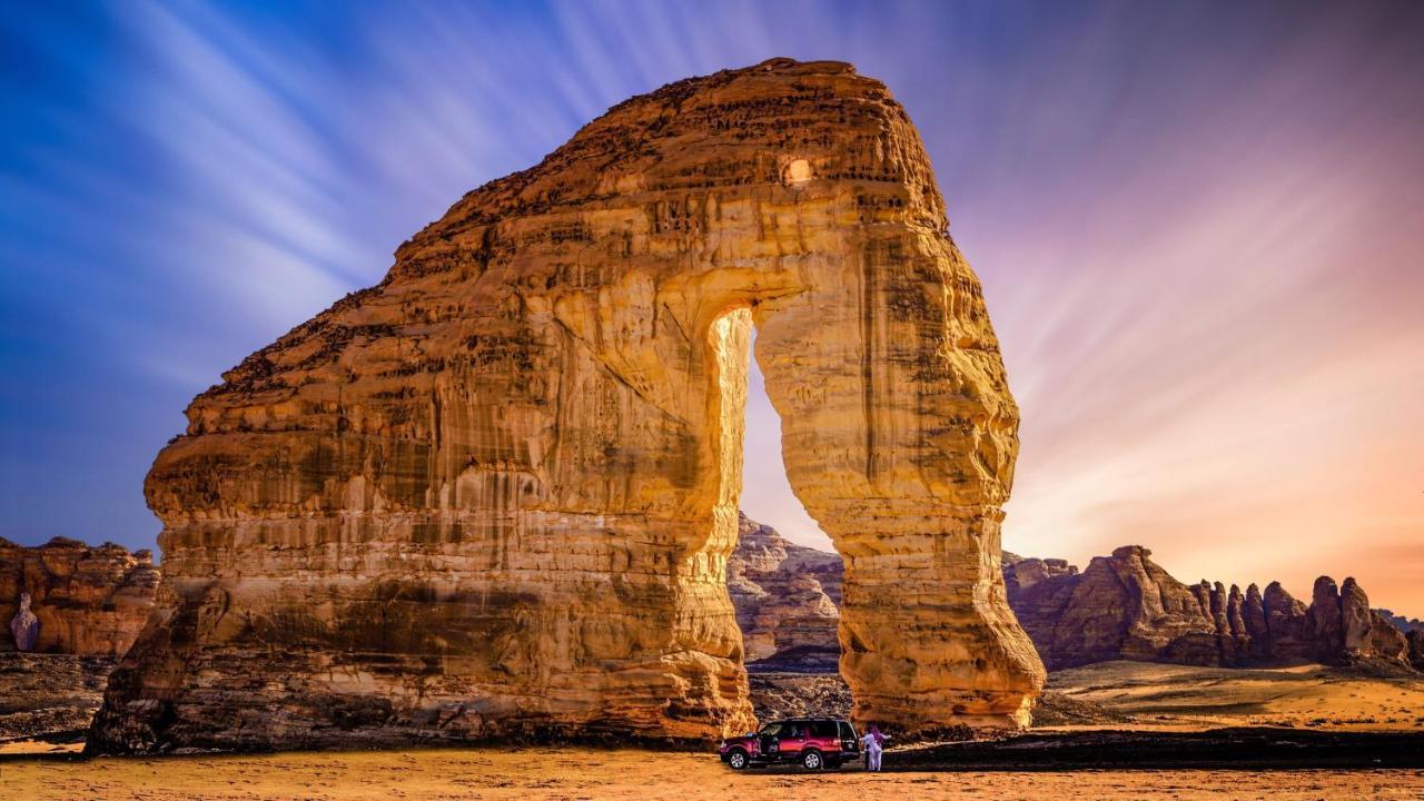 Intercontinental Dar Al Iman Madinah By Ihg Hotel Medina Buitenkant foto The photo depicts a striking rock formation, characterized by a large archway that has been sculpted by natural processes. The landscape around the formation features sandy terrain and rugged terrain, typical of desert environments. In the foreground