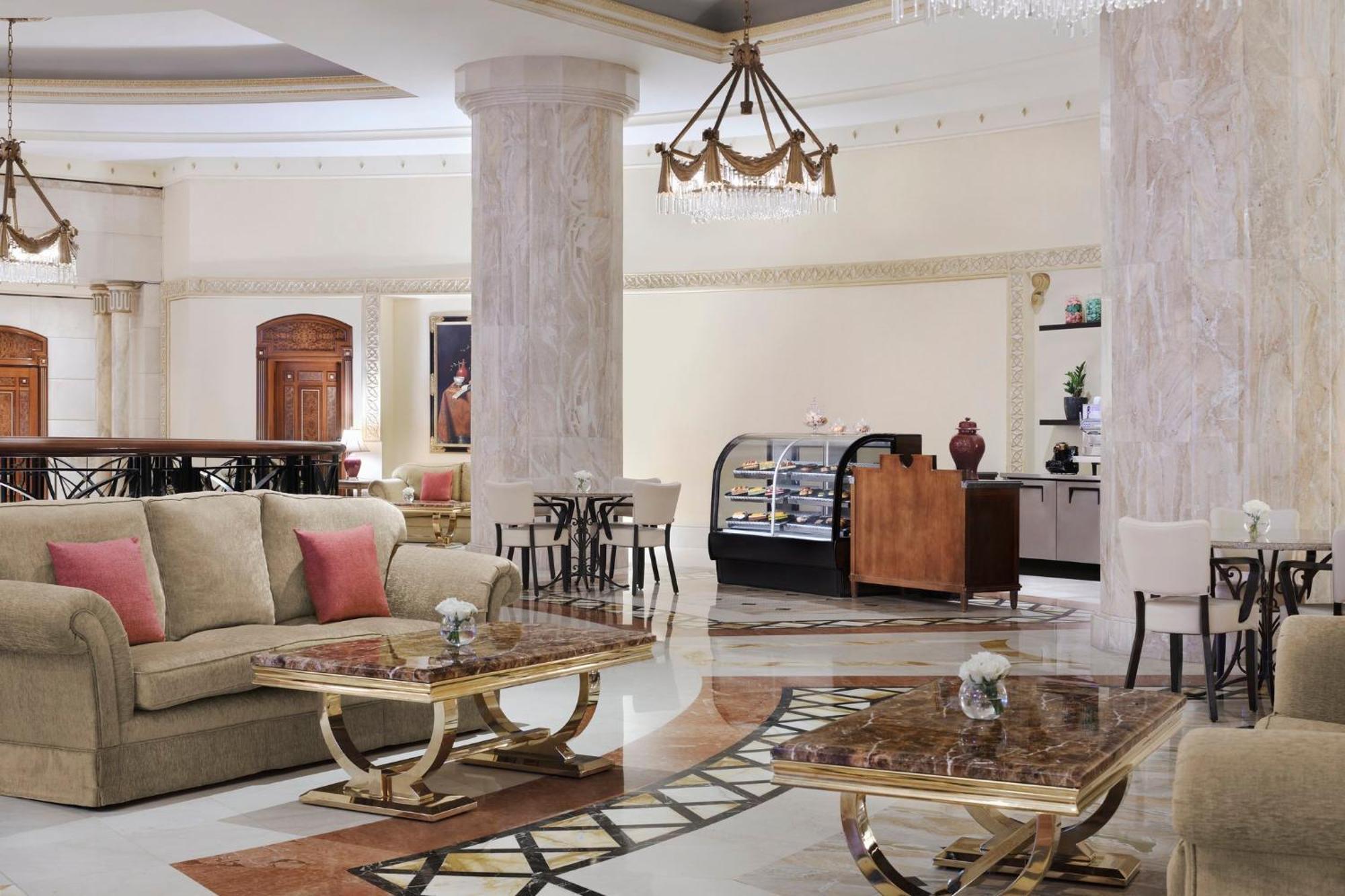 Intercontinental Dar Al Iman Madinah By Ihg Hotel Medina Buitenkant foto The image shows a spacious and elegantly designed hotel lobby or lounge area. It features plush sofas with cushions, stylish coffee tables, and decorative elements. The decor includes marble columns and a chandelier hanging from the ceiling, adding t